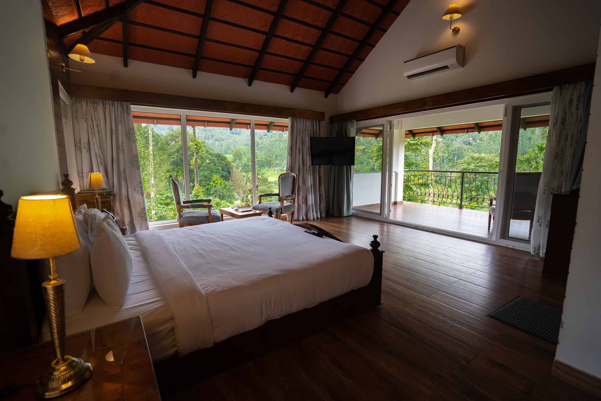 Cottage bedroom with forest view balcony. RiverMist Resorts.