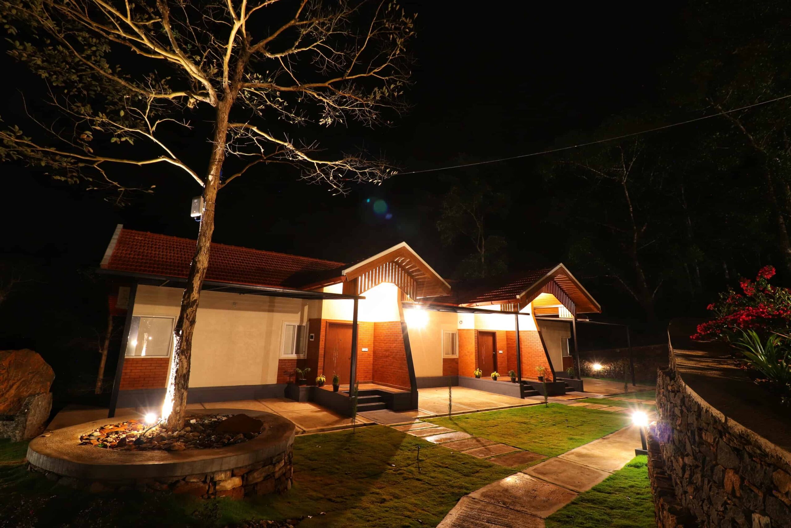 Night view of lit premium cottage exterior. RiverMist Resorts.