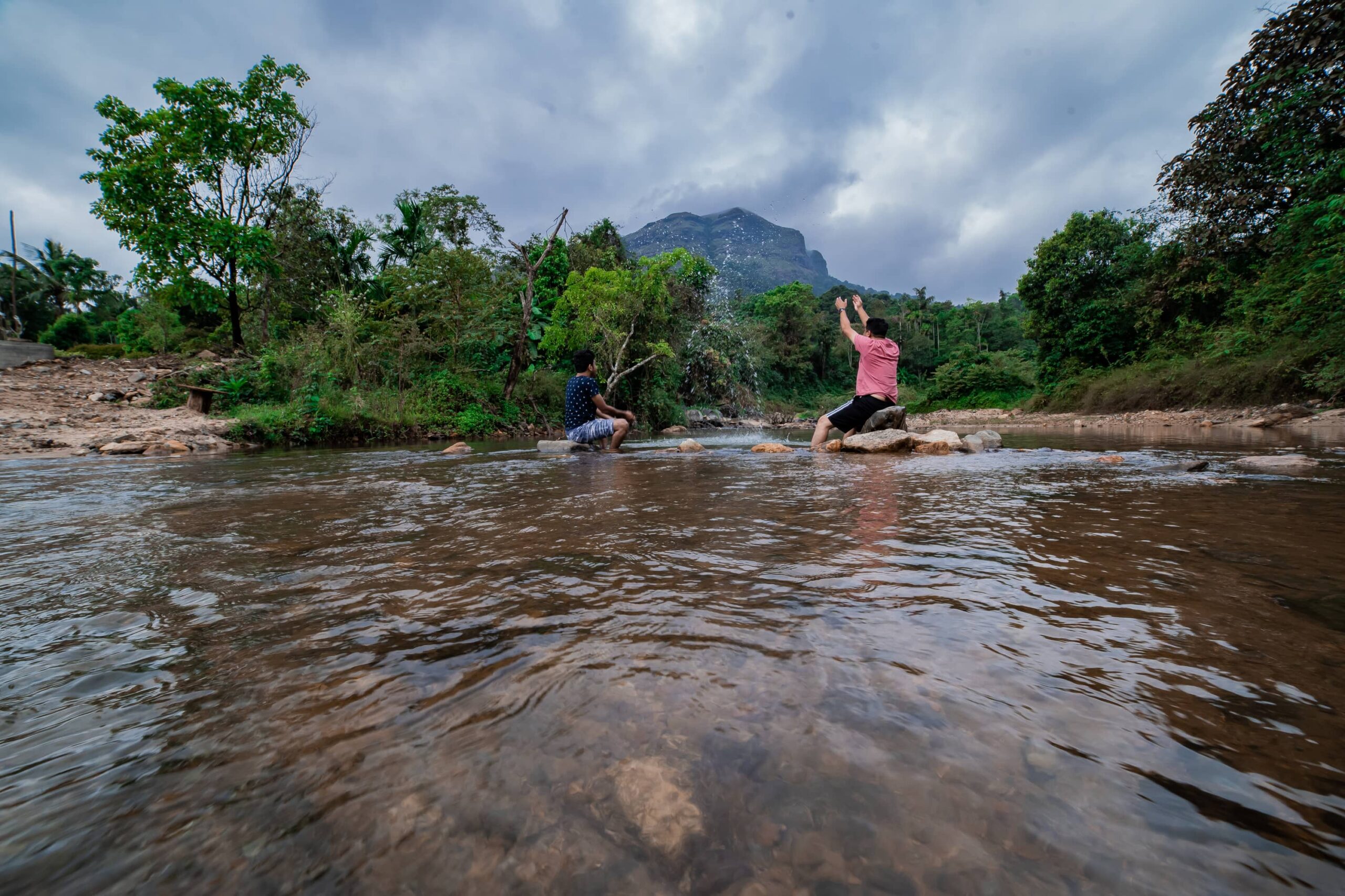 Guests relaxing in rocky river. RiverMist Resorts nature.