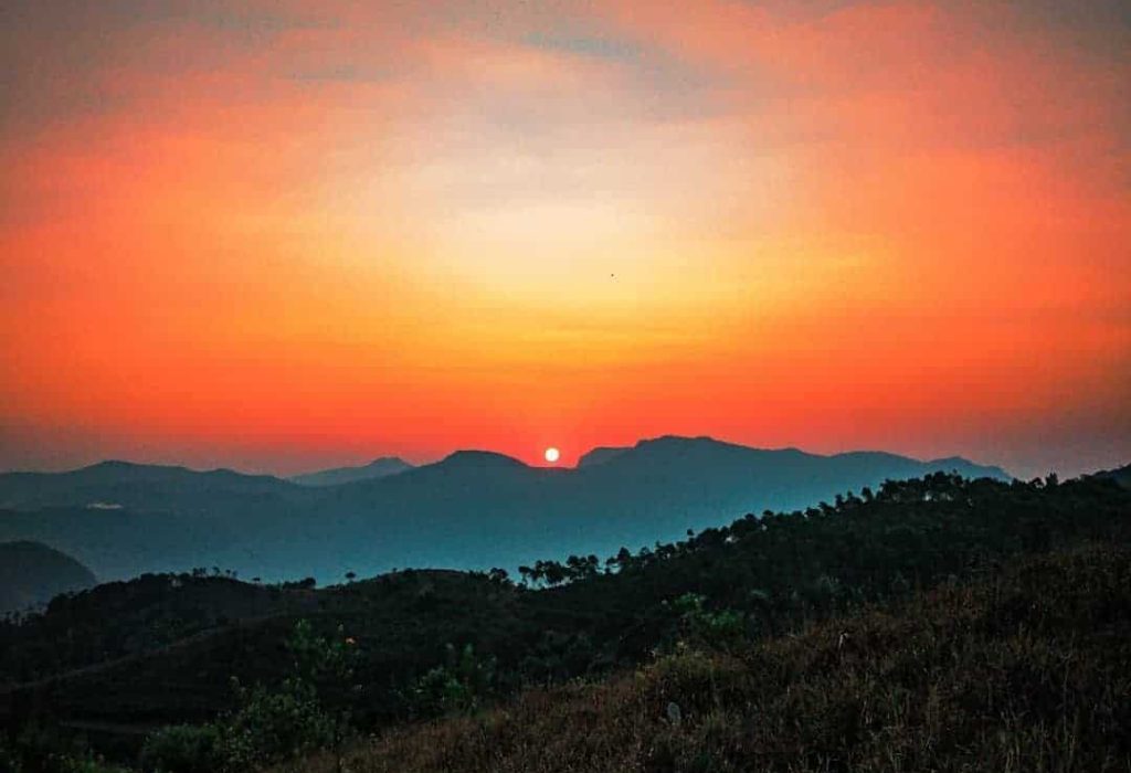 Vibrant sunrise over silhouetted mountains. Ballalarayana Durga.