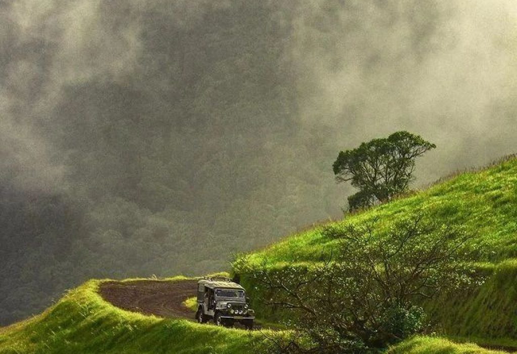 Jeep on winding road in misty Kodachadri mountains. Karnataka.